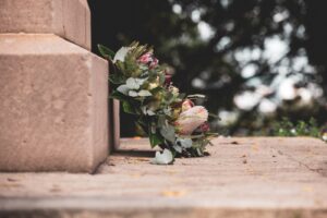 pink and green flower bouquet on brown concrete wall