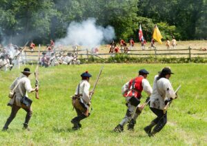a group of men in uniforms holding rifles and a flag