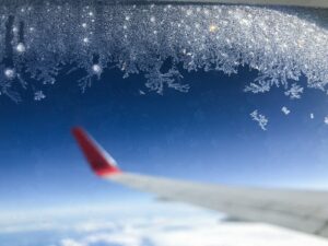 An airplane wing with snow flakes on it